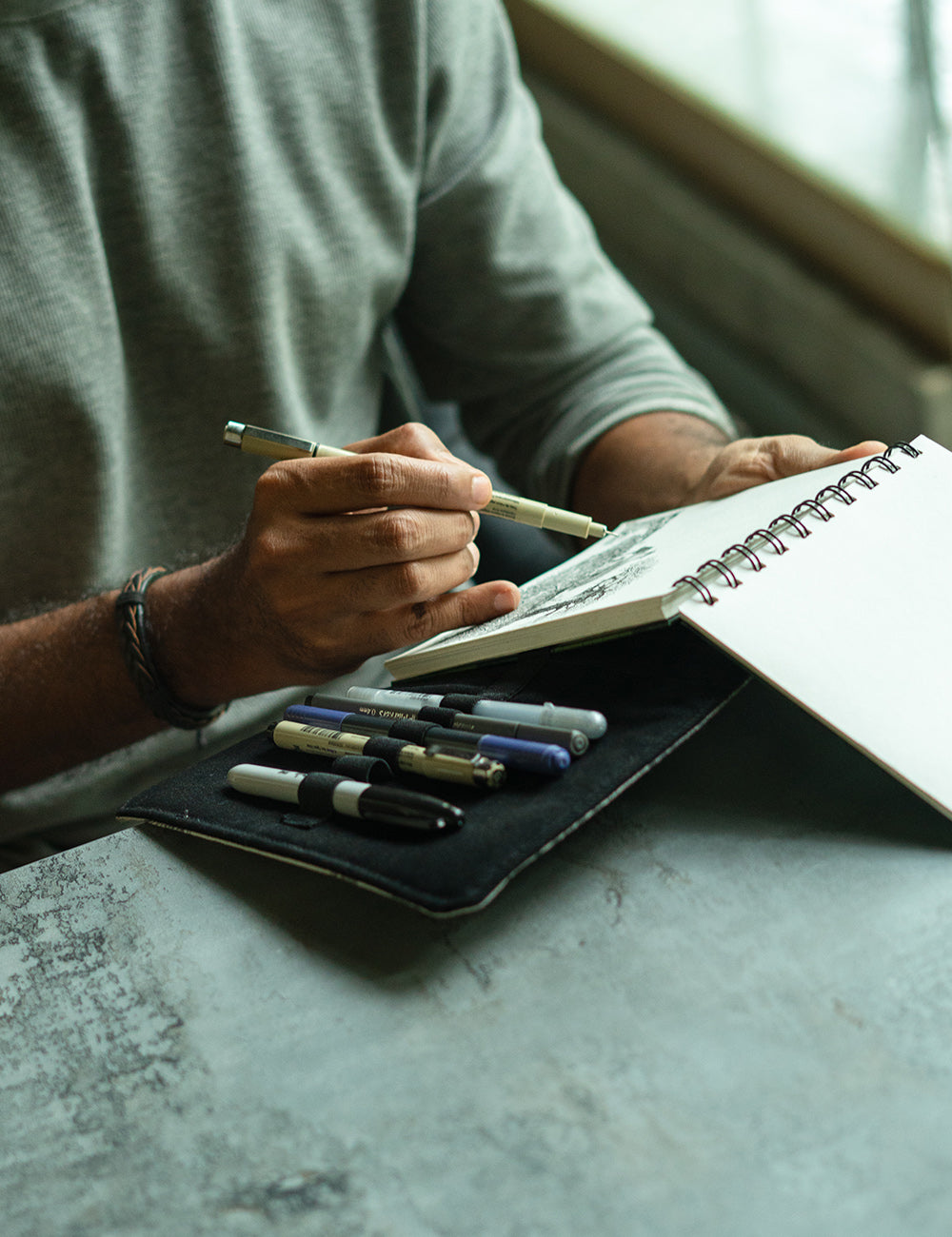 An artist comfortably sketching at a cafe with his Lilorosh outdoor sketching kit.